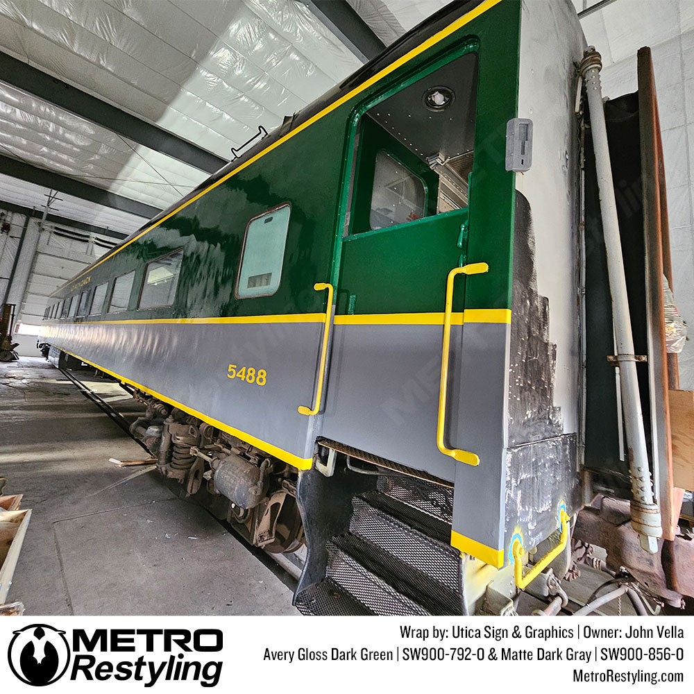railroad car wrapped with green, gray, and yellow vinyl
